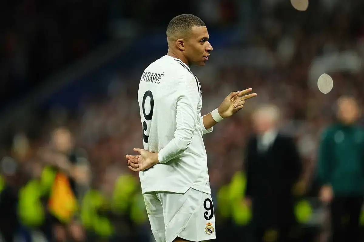 Kylian Mbappé, młody piłkarz, pokazuje dwa palce, być może nawiązując do tego, ile lat ma Mbappe.