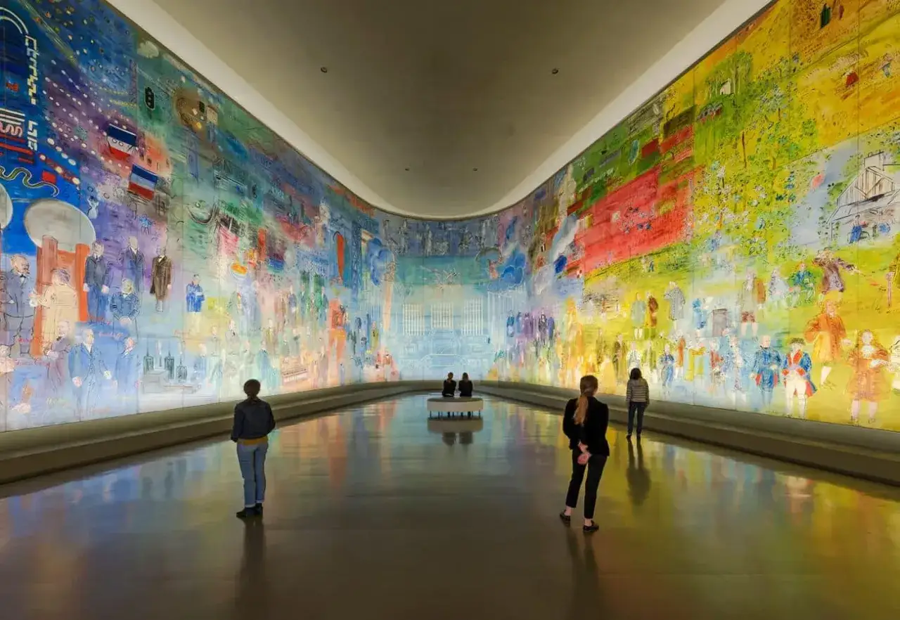 Des visiteurs contemplent une fresque colorée et foisonnante, une expo gratuite à Paris.