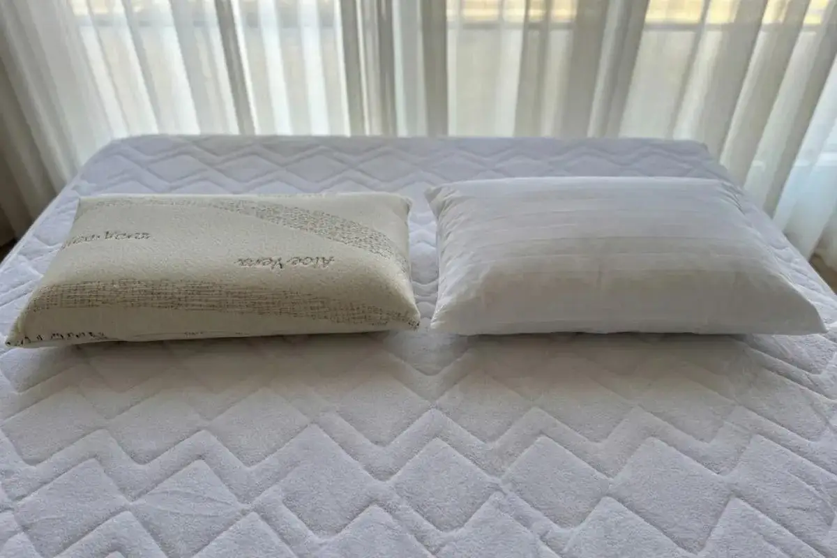 Dos almohadas sobre un colchón: una de fibra con Aloe Vera y otra viscoelástica. ¿Qué es mejor almohada de fibra o viscoelástica?