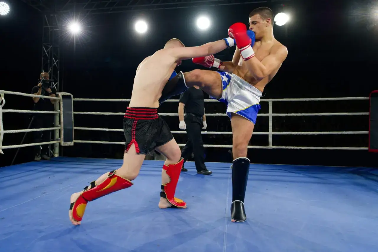 Tv&aring; k1 fighters i en ring, en sparkar mot den andra. En kameraman filmar matchen.