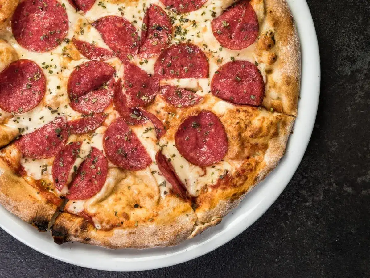 Eine köstliche Pizza mit vielen Scheiben würziger Salami, die verschiedene Salami-Sorten repräsentiert.