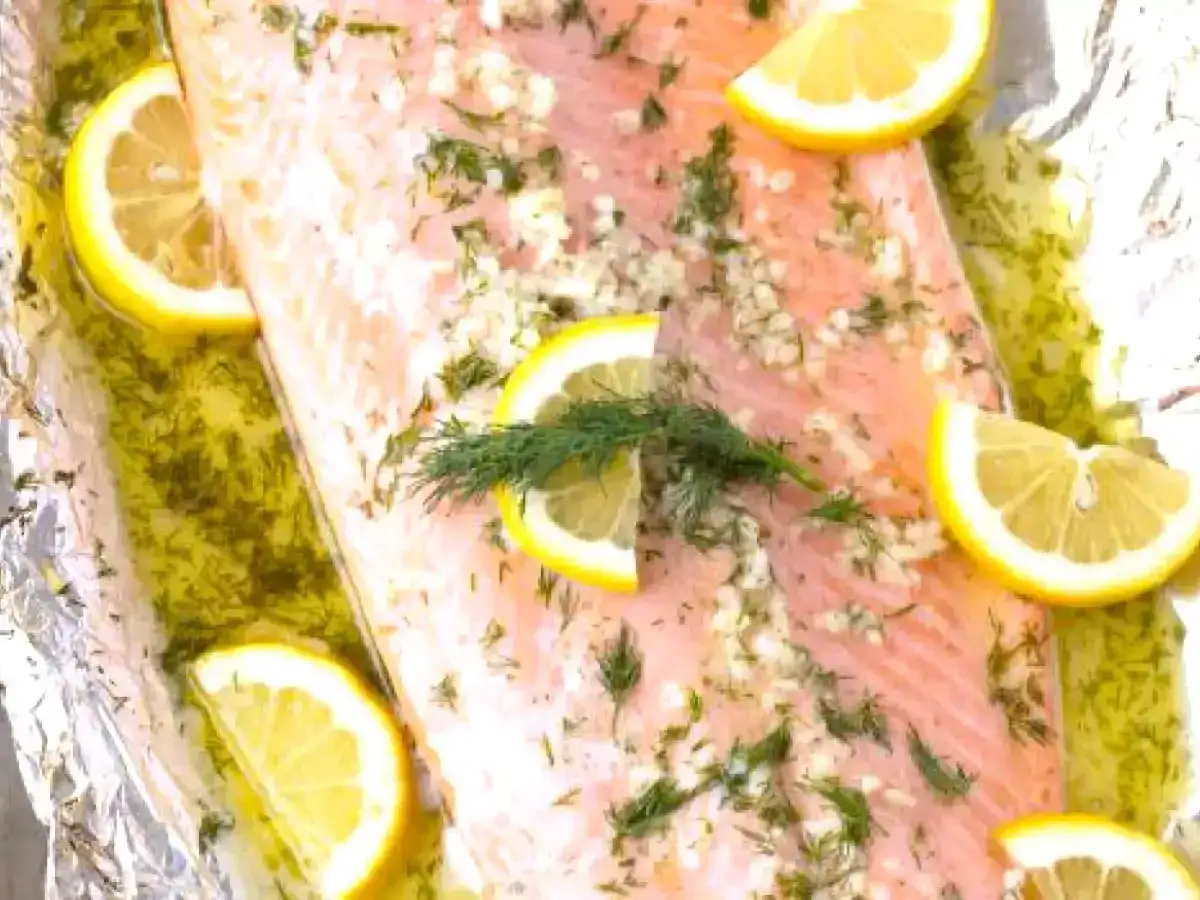 Un délicieux saumon au four, paré de rondelles de citron et d'aneth frais, prêt à être dégusté.