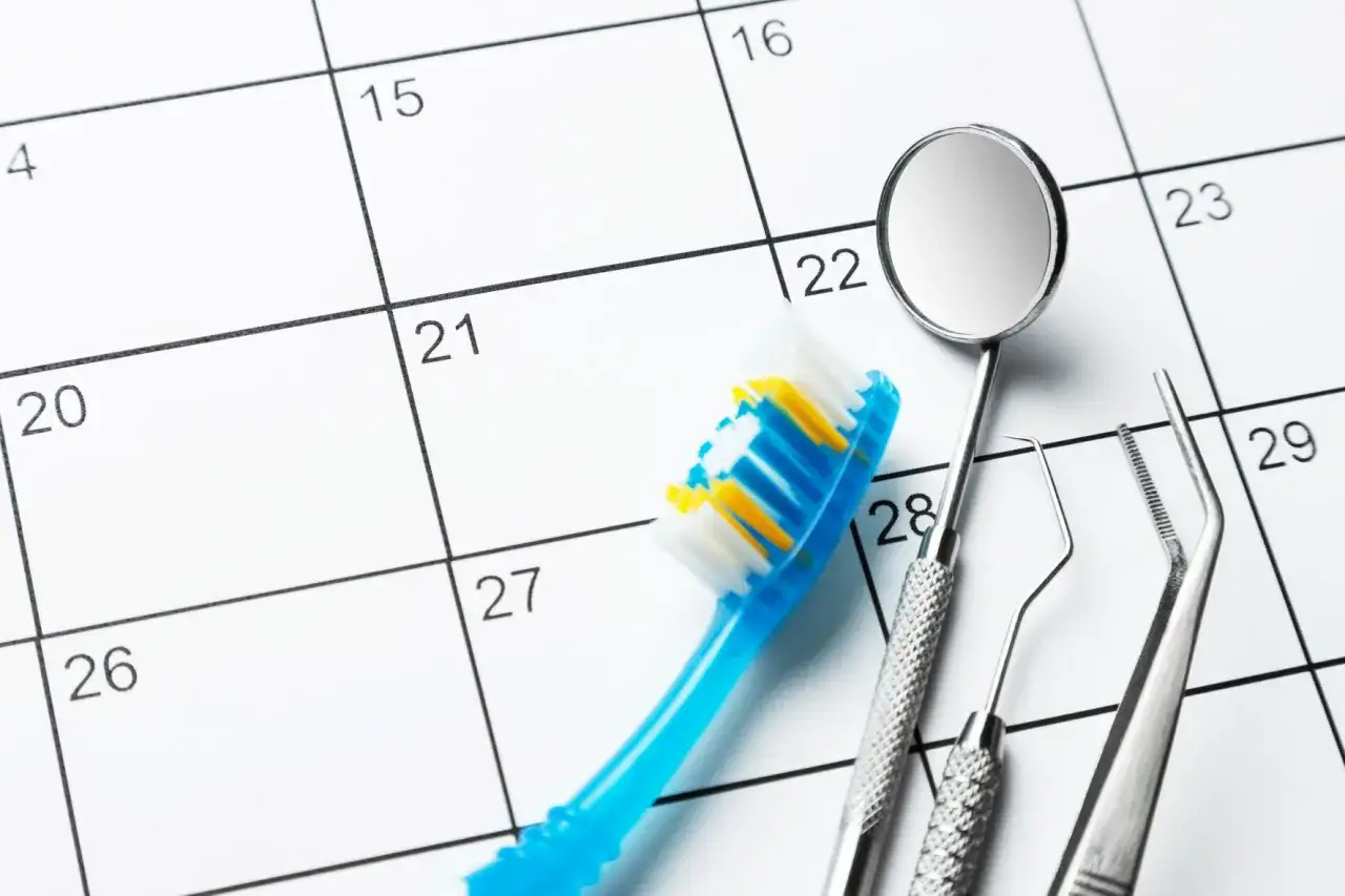 Spazzolino e strumenti dentali su un calendario. La segretaria dello studio dentistico organizza gli appuntamenti.