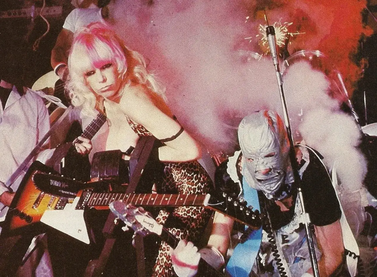 Zwei Musiker mit auff&auml;lligen Outfits und Gitarren, bereit f&uuml;r energiegeladene Punk-Songs. Rauch und Funken sorgen f&uuml;r dramatische Stimmung.
