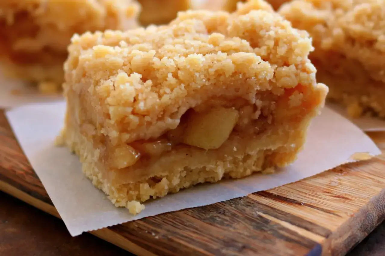 Un delizioso crumble di mele, con strati di mele morbide e una crosta dorata e friabile, pronto per essere gustato.