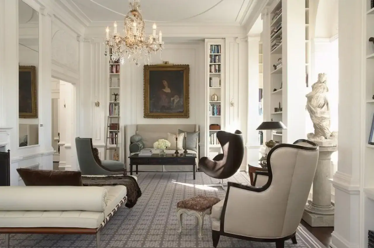 Elegant living room with a crystal chandelier, antique painting, and plush seating, reminiscent of grand Victorian houses.