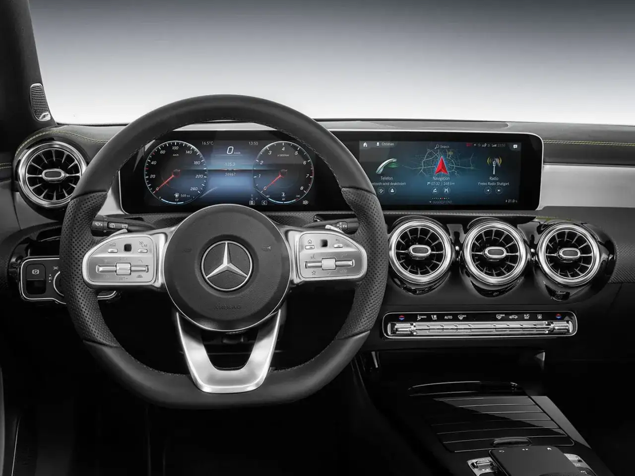 Interior de modelos Mercedes Clase A: volante, pantallas digitales con navegaci&oacute;n y radio, y salidas de aire.