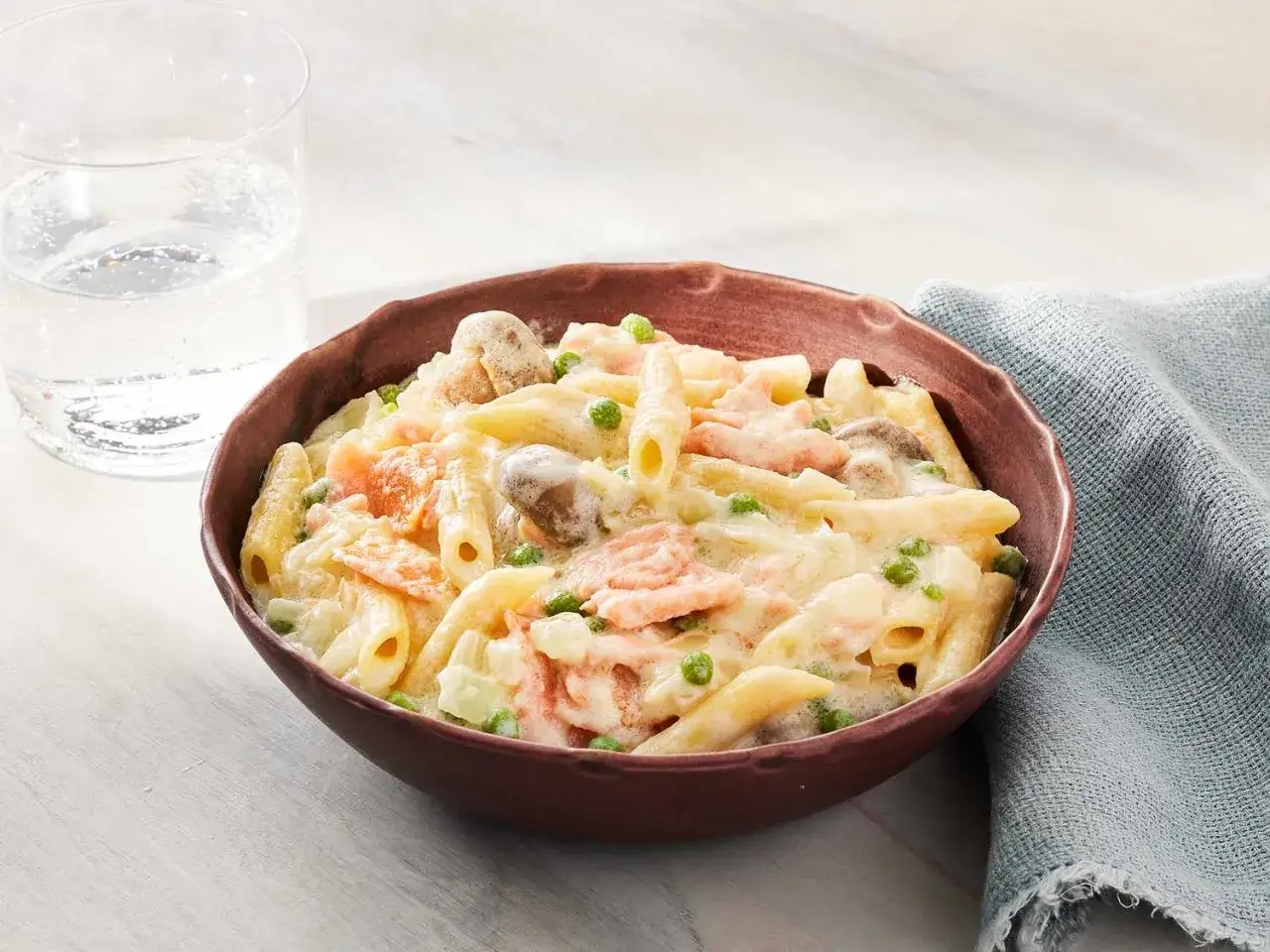 Deliciosa pasta con salmón ahumado, champiñones y guisantes en una cremosa salsa.