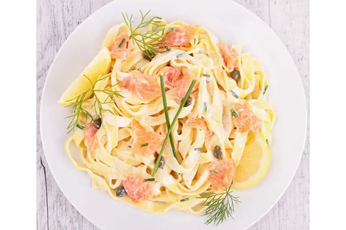 Assiette de tagliatelles au saumon, crémeuses et garnies de câpres, d'aneth et de quartiers de citron. Un délice !