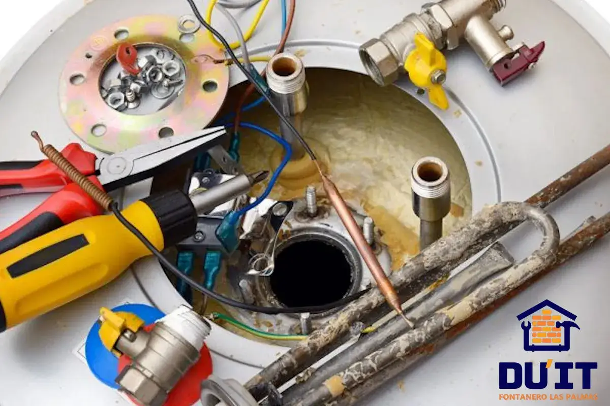Herramientas y componentes para saber c&oacute;mo cambiar un termo el&eacute;ctrico. Se ven cables, tuber&iacute;as y un calentador.