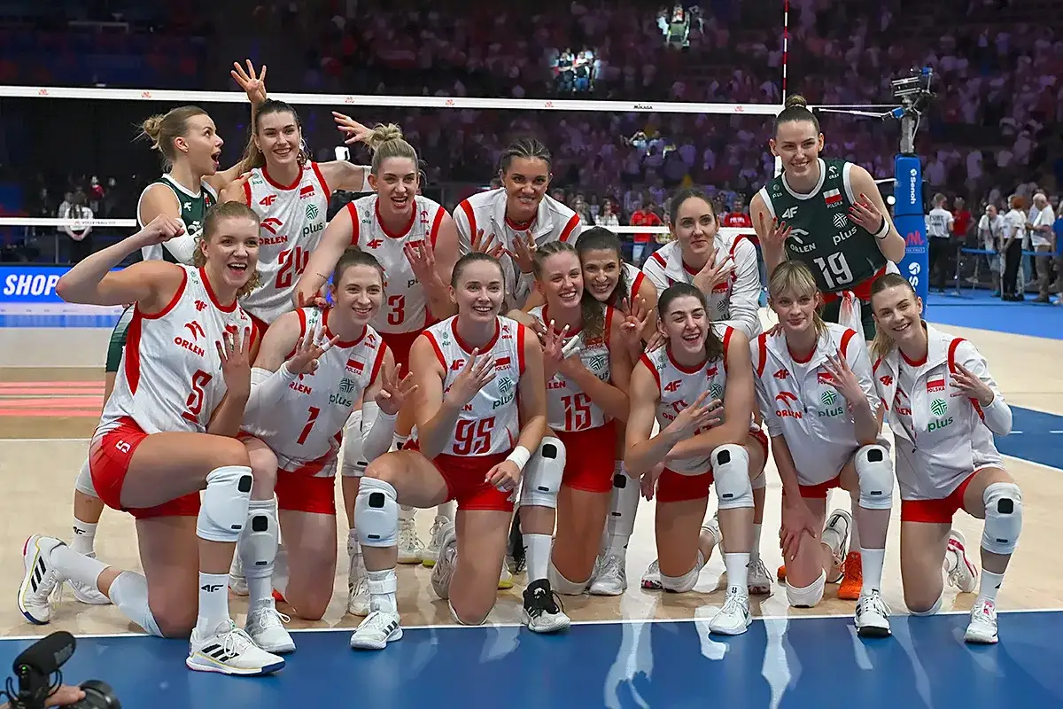 Uśmiechnięte siatkarki Polski w biało-czerwonych strojach świętują zwycięstwo. Radość i duma z gry dla kraju!