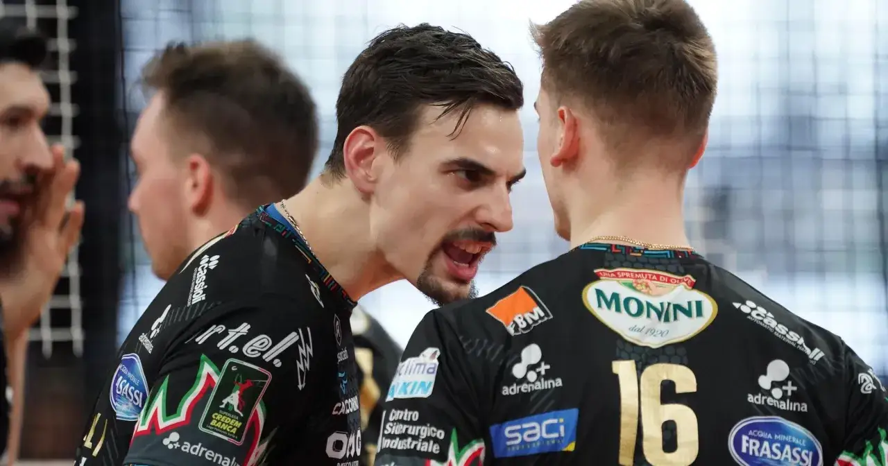 Simone Giannelli, z wyrazem determinacji na twarzy, rozmawia z kolegą z drużyny podczas meczu siatk&oacute;wki.