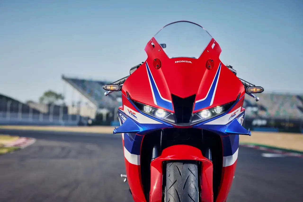 Czerwono-niebieski motocykl Honda CBR 600RR na torze wyścigowym. Poznaj honda cbr 600rr dane techniczne i poczuj moc.