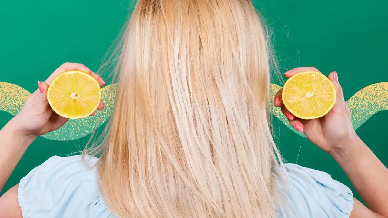 Kvinnan med blont hår håller upp citronhalvor vid öronen, som om hon vill bleka håret med citron.