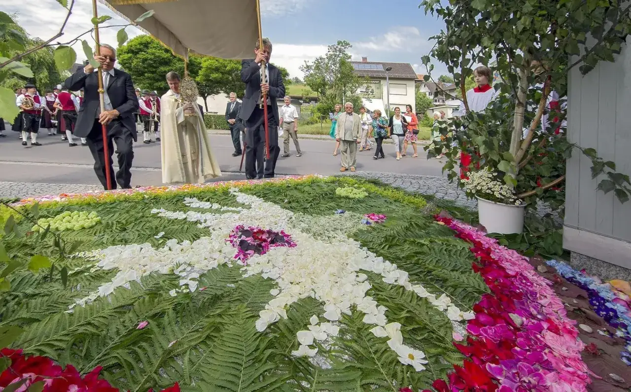 Blumenaltar als Fronleichnamssymbol, geschm&uuml;ckt mit Farn und Bl&uuml;tenbl&auml;ttern, w&auml;hrend einer Prozession.