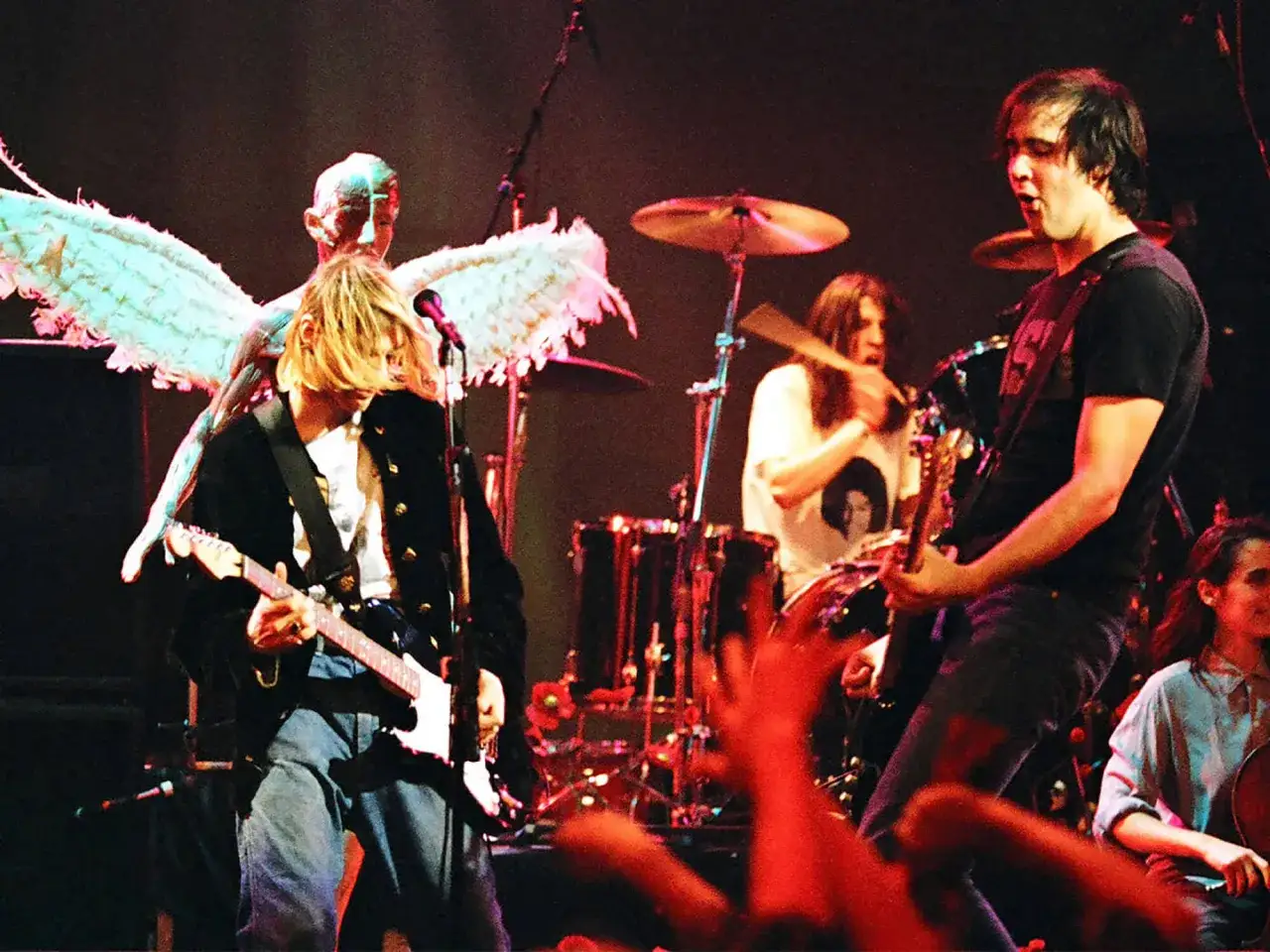 Nirvana członkowie na scenie: Kurt Cobain gra na gitarze, Dave Grohl przy perkusji, Krist Novoselic na basie.
