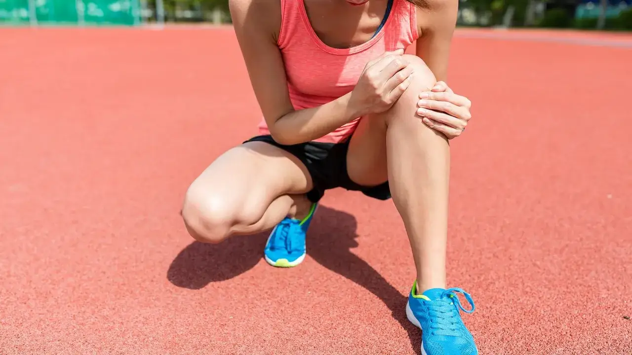 Sportive tenant son genou, peut-être en quête d'un anti inflammatoire avant sport pour soulager une douleur.