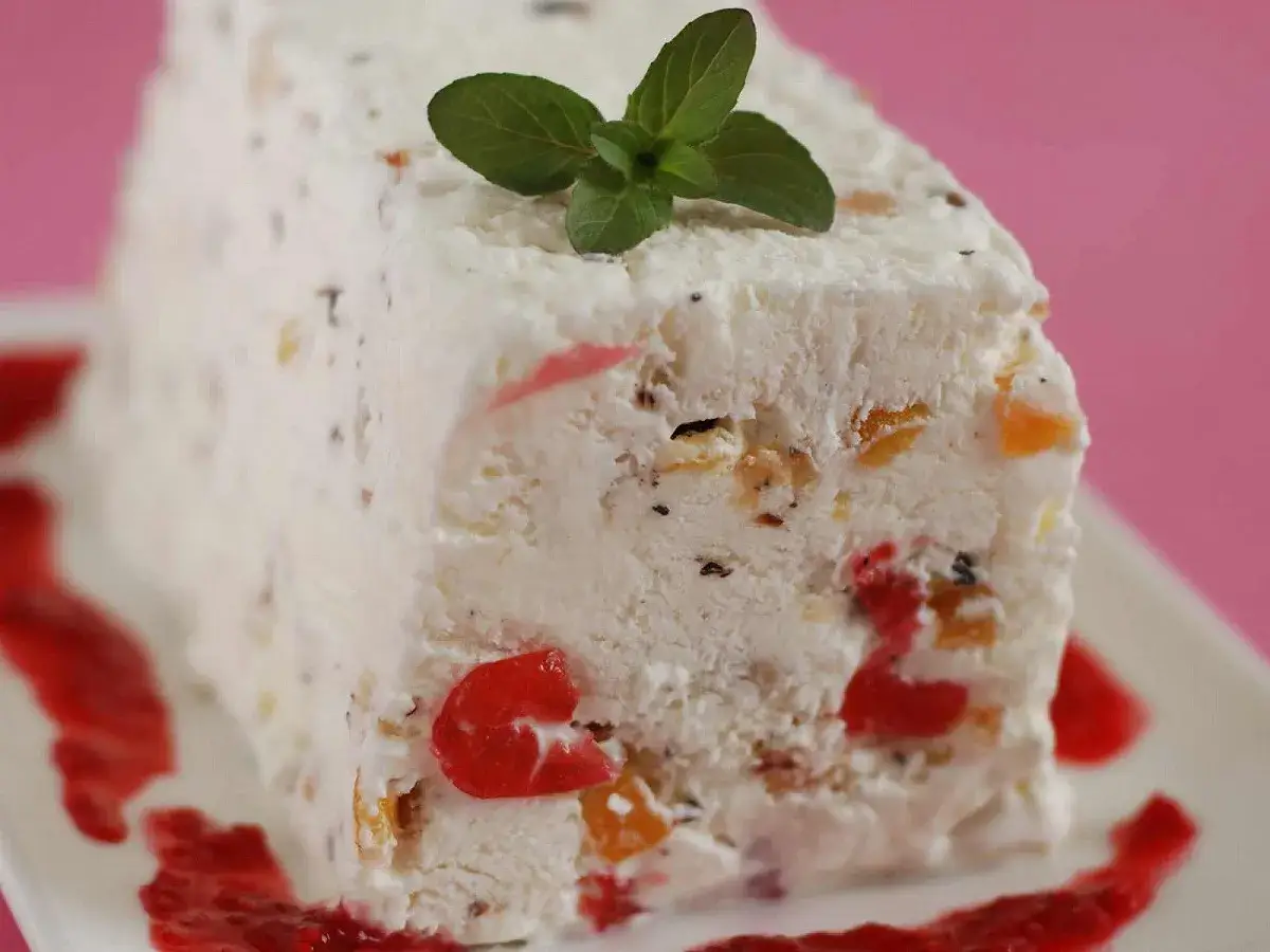 Un d&eacute;licieux nougat glac&eacute; aux fruits confits et aux amandes, garni d'une feuille de menthe fra&icirc;che.