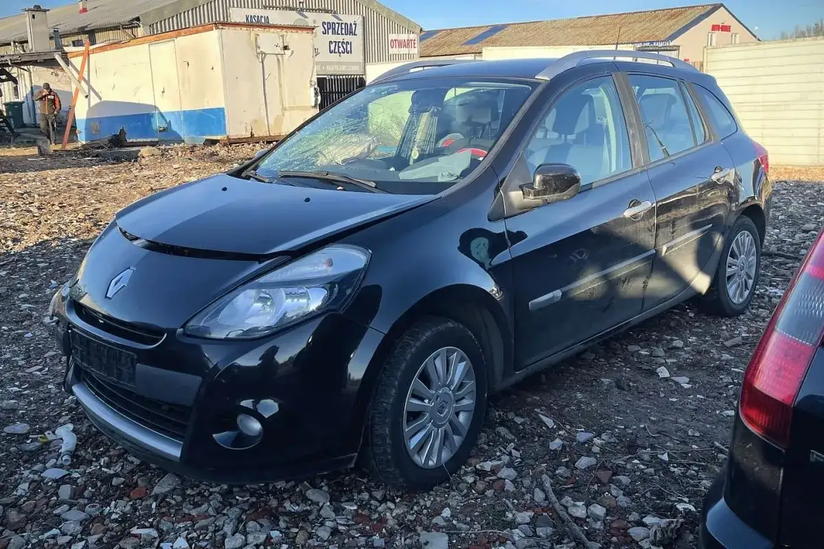 Czarny Renault Clio 3 kombi z otwartą maską, stojący na placu złomowiska.