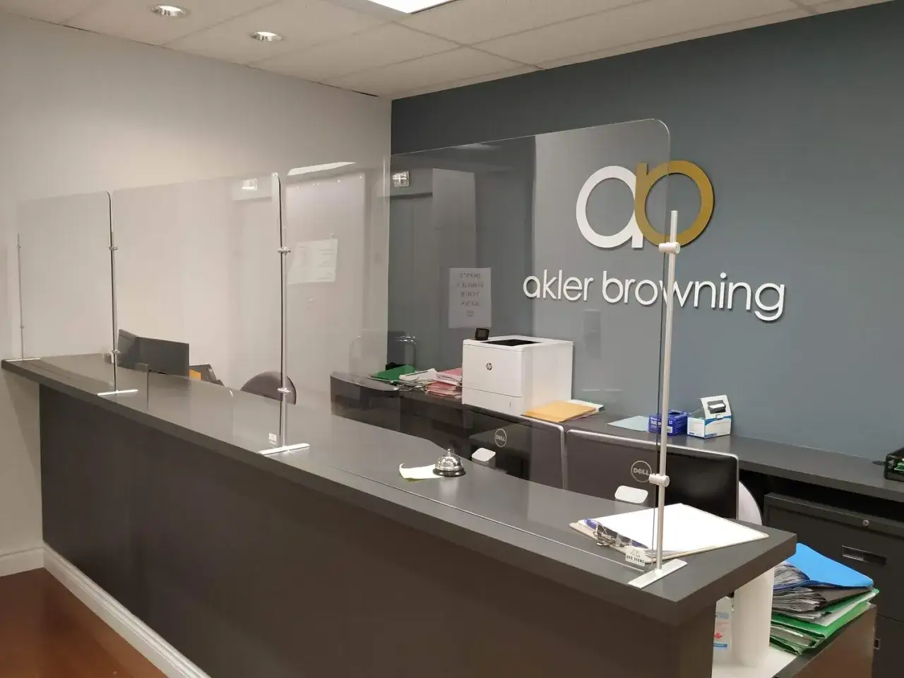 Plexiglass barriers at a reception desk provide a protective shield, demonstrating what is plexiglass used for in public spaces.