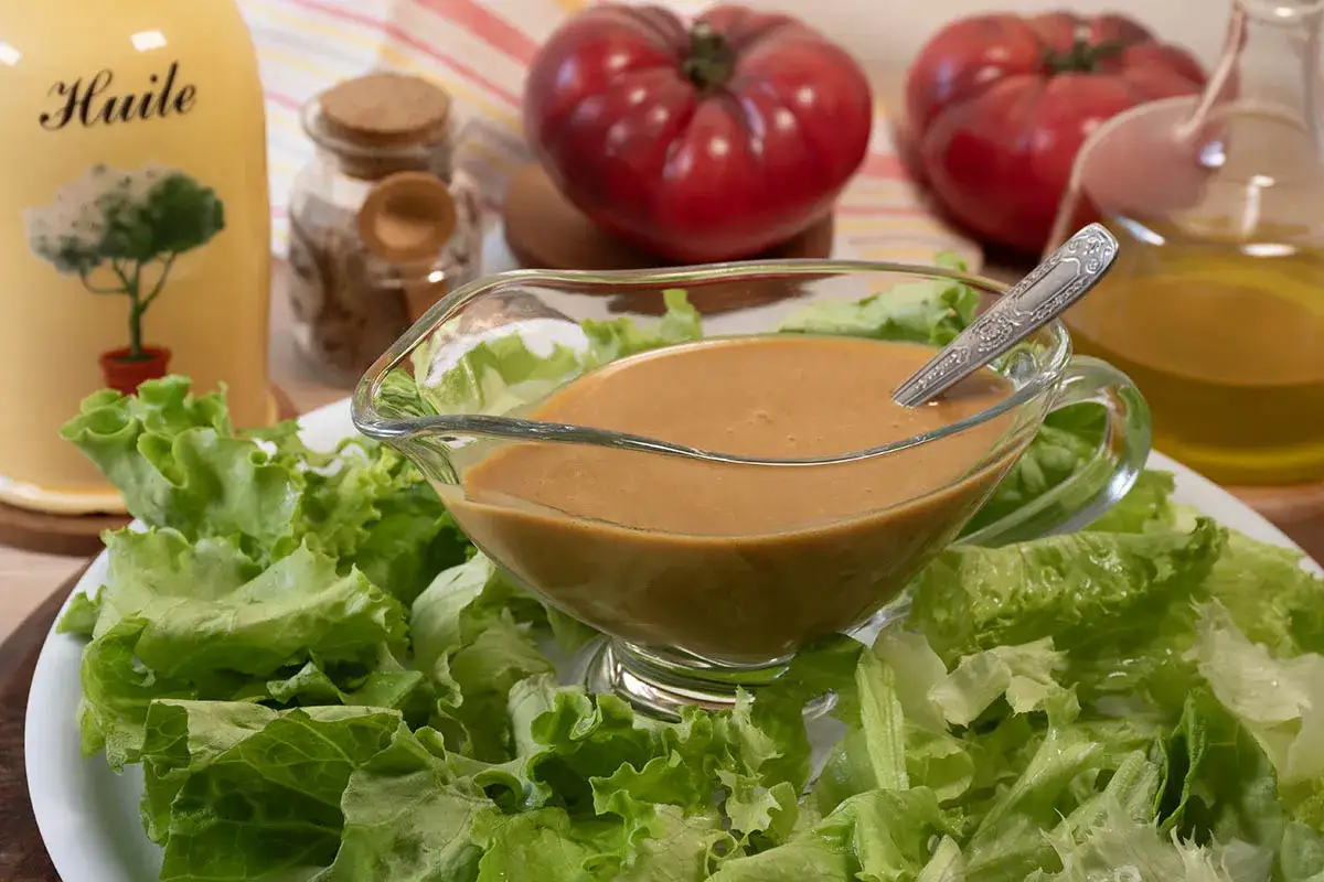 Ensalada fresca con una cremosa vinagreta de mostaza lista para aderezar.