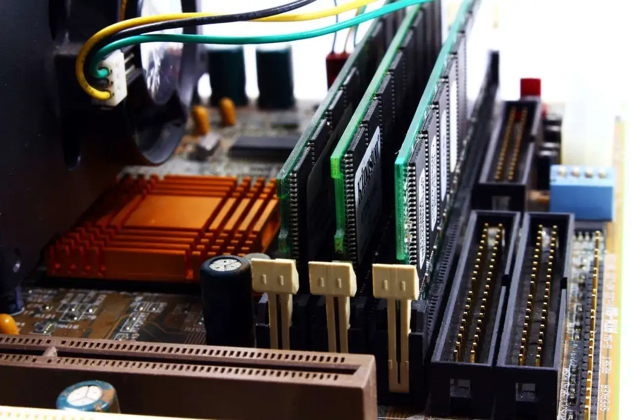 Vue rapprochée de barrettes de RAM installées sur une carte mère, prêtes à améliorer les performances.