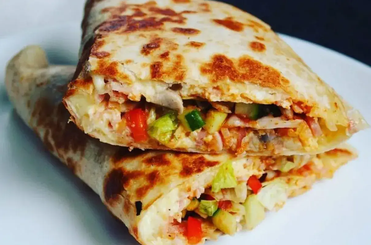 Pyszna tortilla z szynką, warzywami i serem, idealna na szybki posiłek.