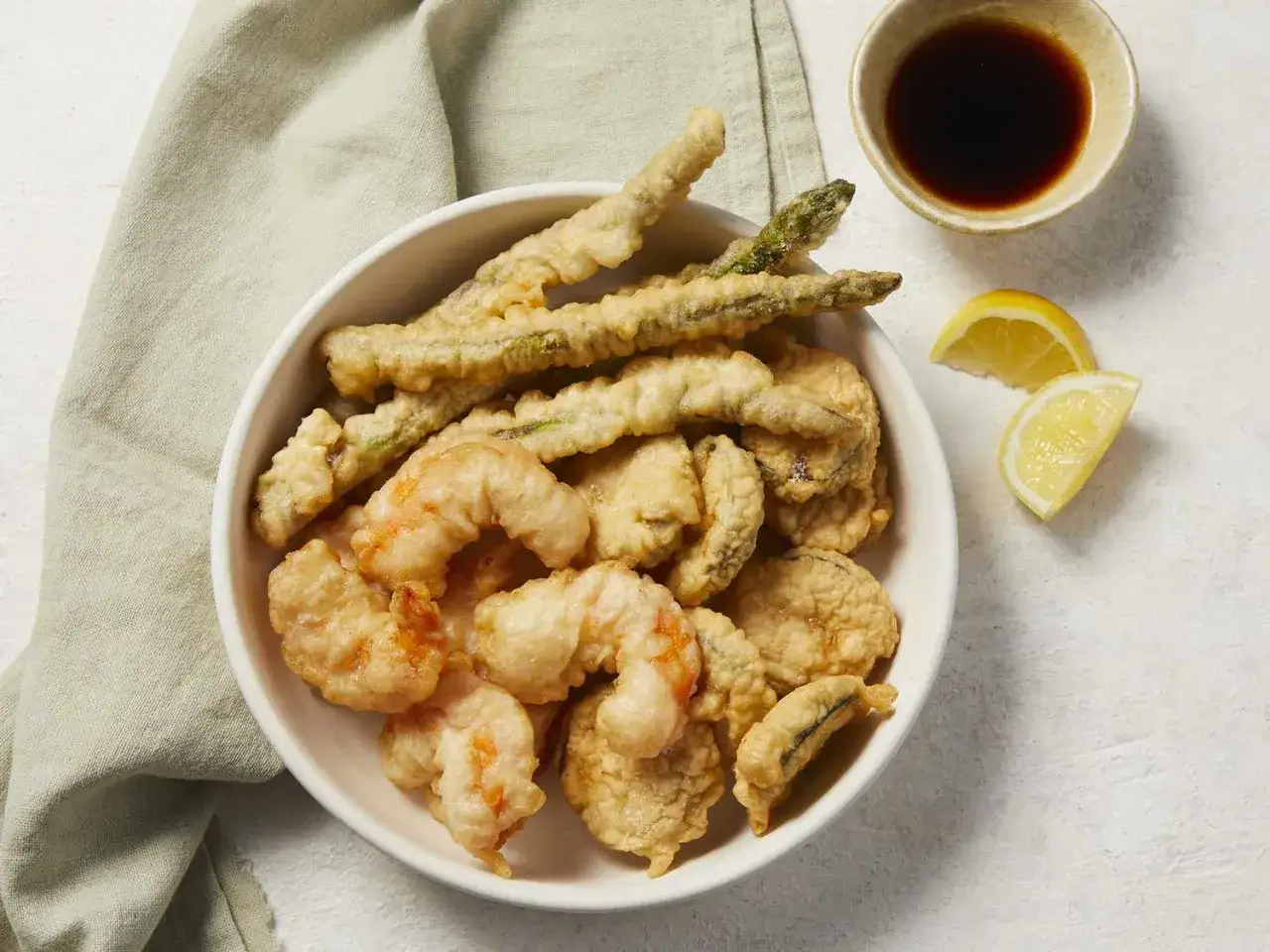 Chrupiące krewetki i szparagi w cieście, idealne do tempura przepis. Podane z cytryną i sosem.