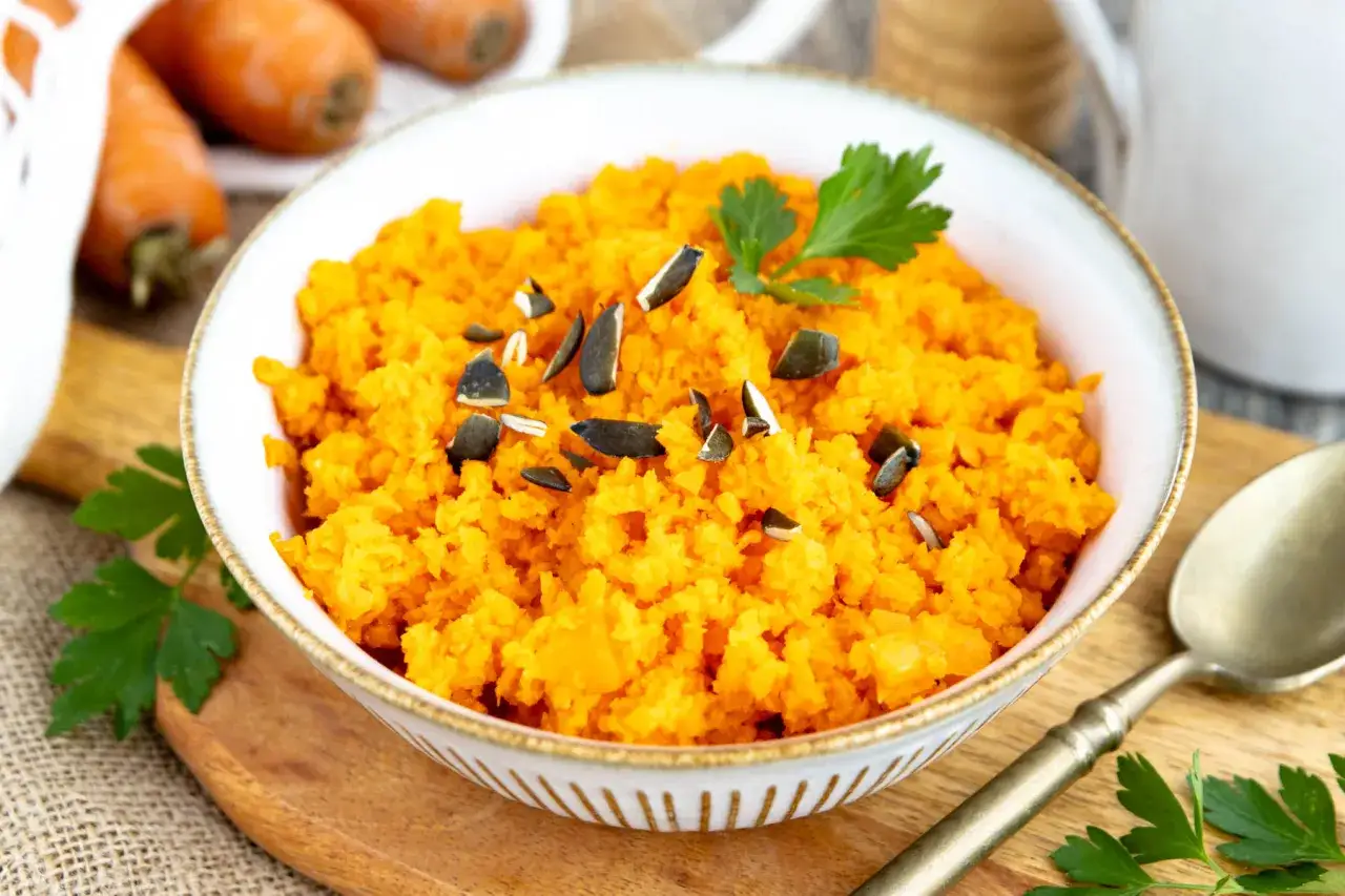 Karottensalat Thermomix, frisch zubereitet und mit Kürbiskernen bestreut, garniert mit Petersilie.