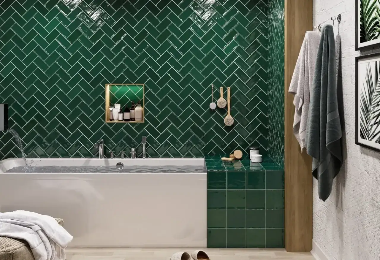 Une **salle de bain travertin et vert** luxueuse avec des carreaux émeraude en chevrons, une baignoire moderne et des accessoires de spa.