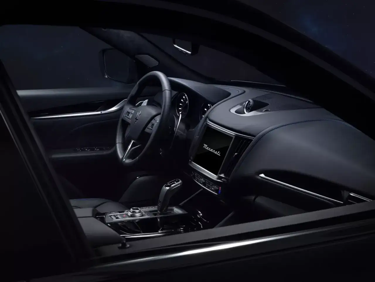 Luksusowe wnętrze Maserati Levante, z niebieskimi przeszyciami i ekranem multimedialnym. Sprawdź aktualną maserati levante cena.