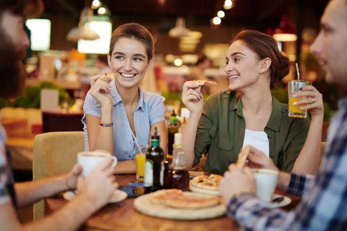 Przyjaciele jedzą pizzę i piją napoje. Czy cheat day przyspiesza metabolizm?