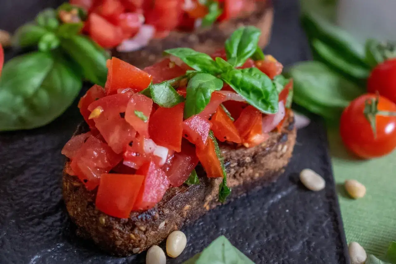 Ein k&ouml;stliches rezept bruschetta original italienisch: ger&ouml;stetes Brot mit frischen Tomaten, Basilikum und Pinienkernen.
