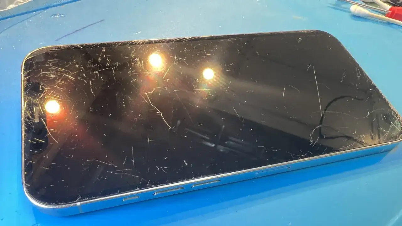 Telefon z licznymi zarysowaniami na ekranie, przygotowany do polerowania.
