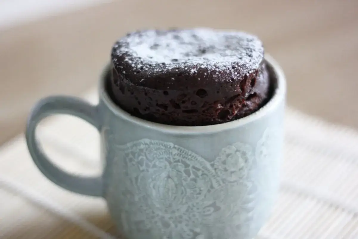 Delicioso bizcocho a la taza de chocolate, espolvoreado con azúcar glas. Perfecto para un antojo rápido.