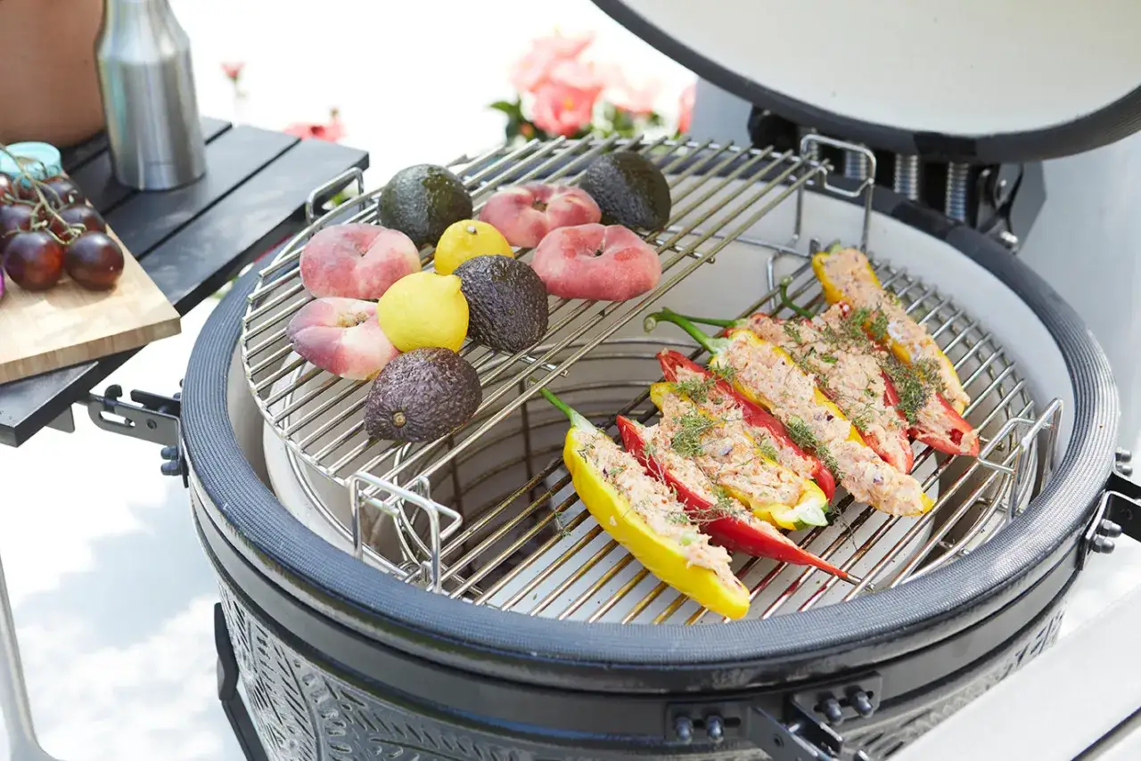 Poivrons farcis et fruits sur un kamado. Avis positif pour ce barbecue, id&eacute;al pour des grillades vari&eacute;es.