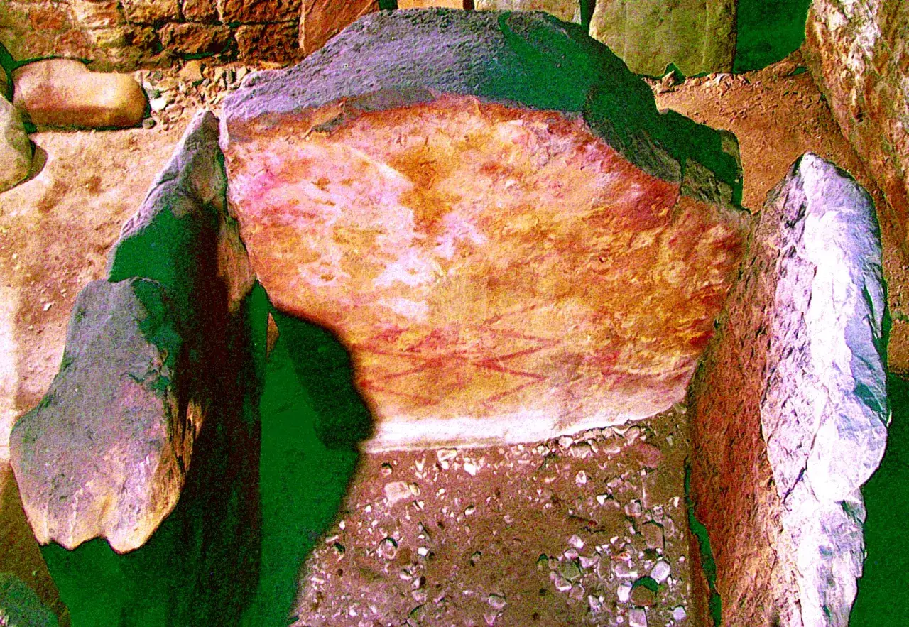 Antiguos grabados en el dolmen y capilla de Santa Cruz, con pigmentos rojizos sobre piedra.