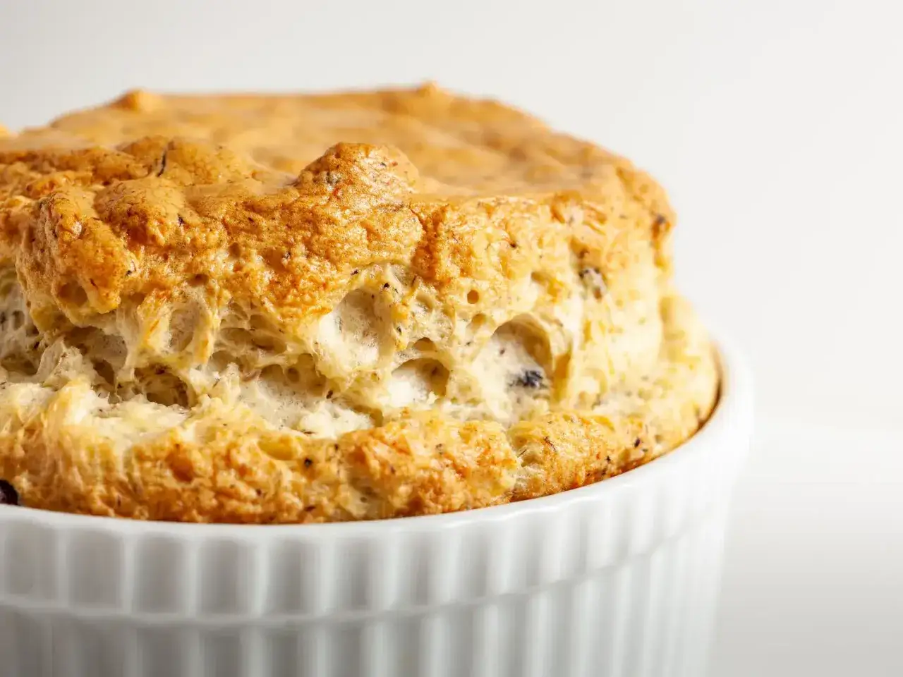 Un souffl&eacute; au fromage dor&eacute; et a&eacute;rien, gonfl&eacute; &agrave; souhait dans son ramequin blanc.