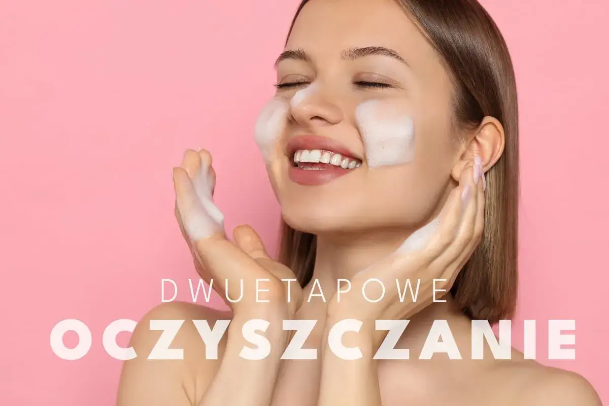 Uśmiechnięta kobieta wykonuje dwuetapowe oczyszczanie twarzy w domu, delikatnie masując skórę pianką.