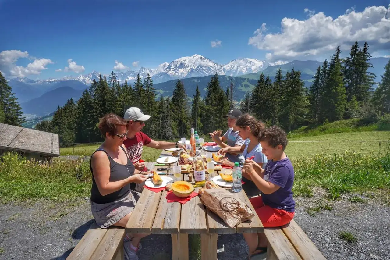 Une famille profite d'un pique-nique en montagne, une belle id&eacute;e de que manger en randonn&eacute;e. Le Mont Blanc en toile de fond.