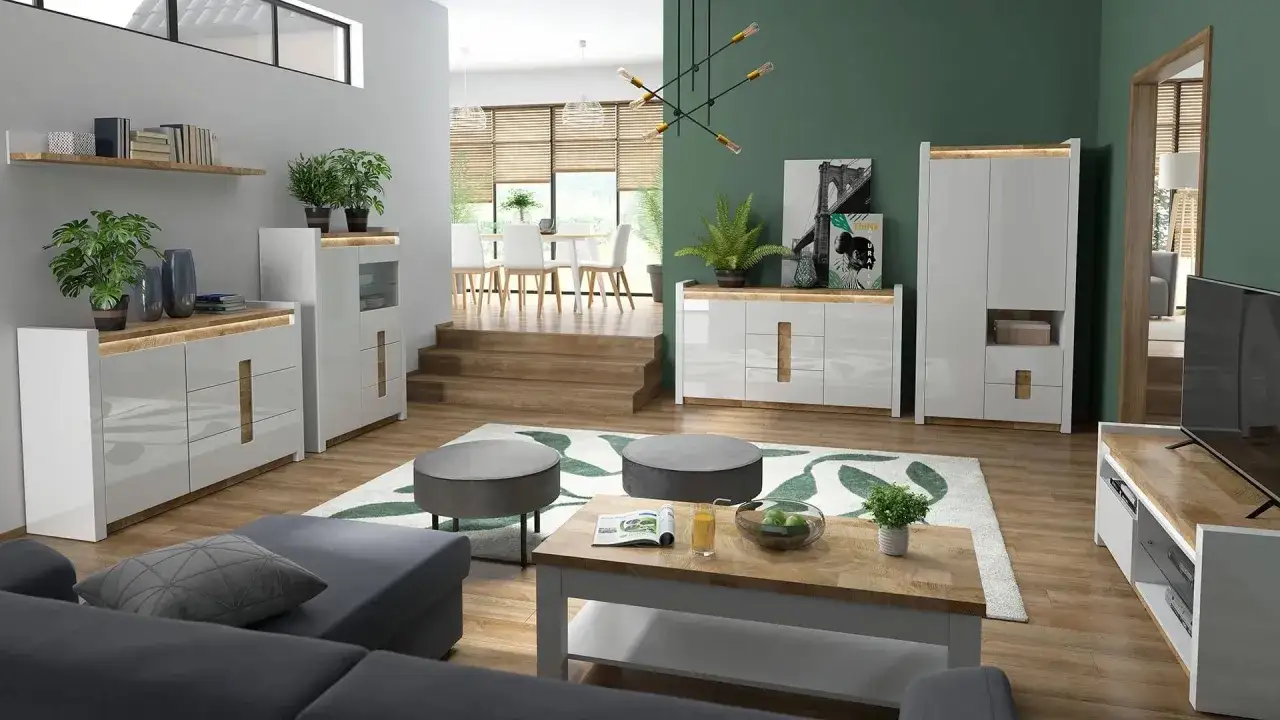 Nowoczesny pokój z zieloną ścianą, białymi meblami i drewnianymi akcentami. Wygodna sofa, stolik kawowy i dywan z motywem liści tworzą przytulną atmosferę.