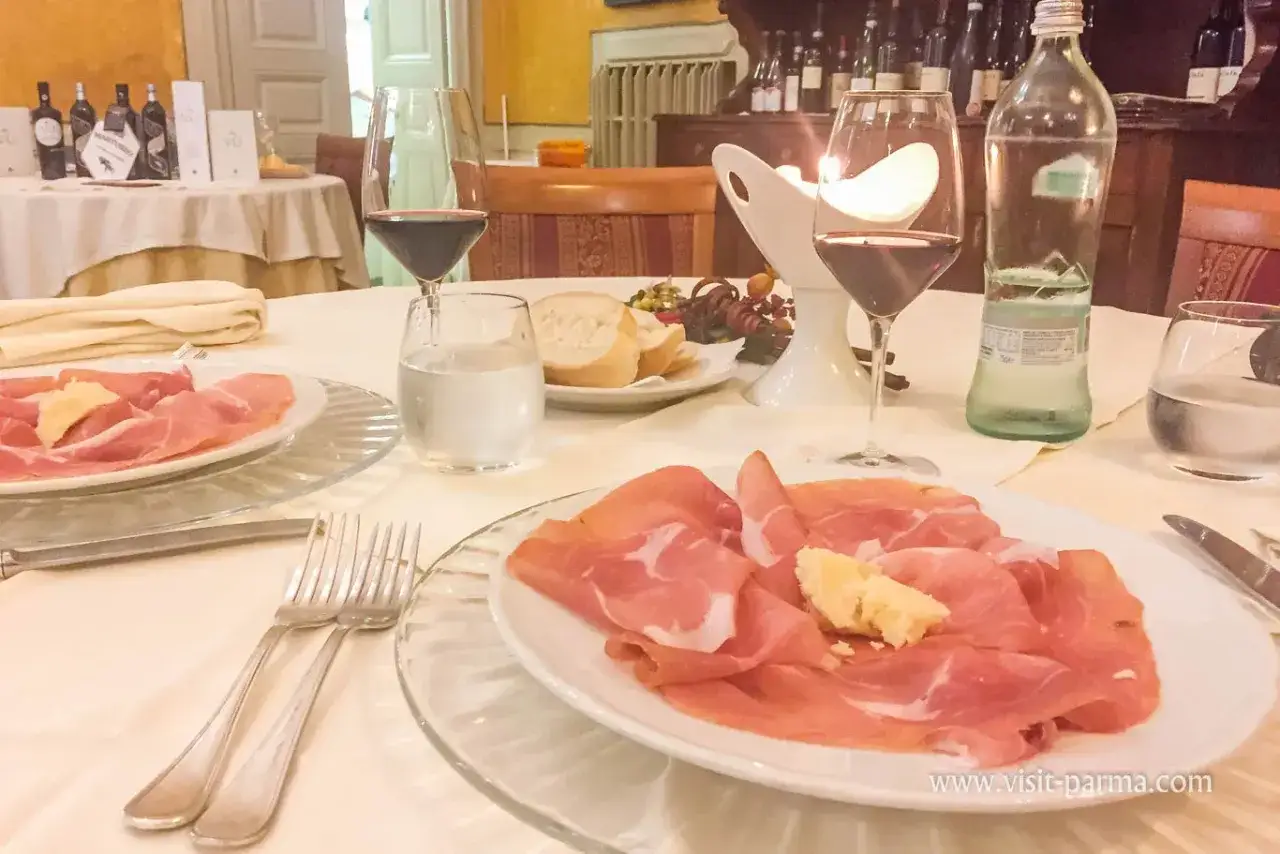 Salumi e vino rosso in un ristorante di Parma, un'esperienza culinaria da provare.