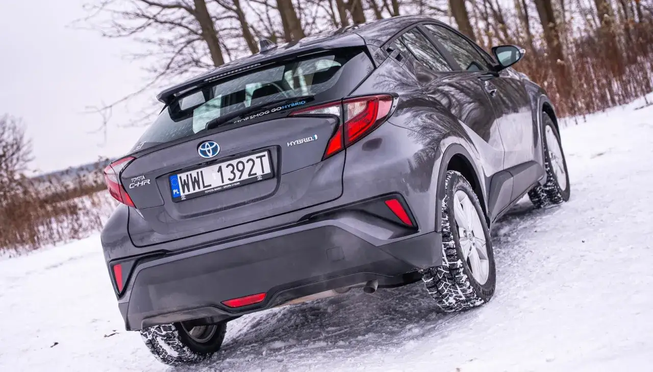 Szara Toyota C-HR Hybrid 2022 na śniegu, gotowa na zimowe wyzwania.