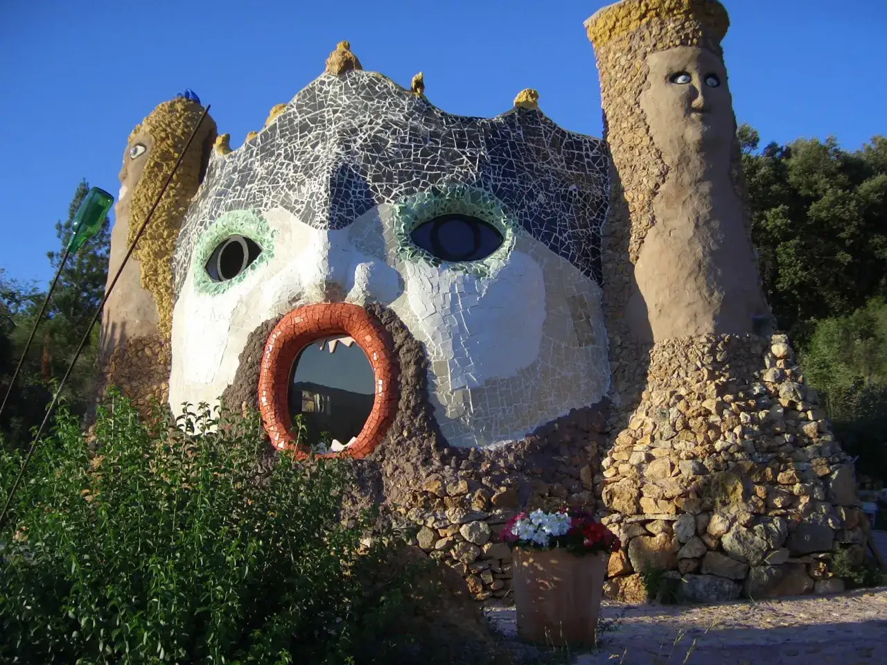 El jardín de Peter es un lugar mágico con una casa con forma de cara gigante, ojos de mosaico y una boca circular.