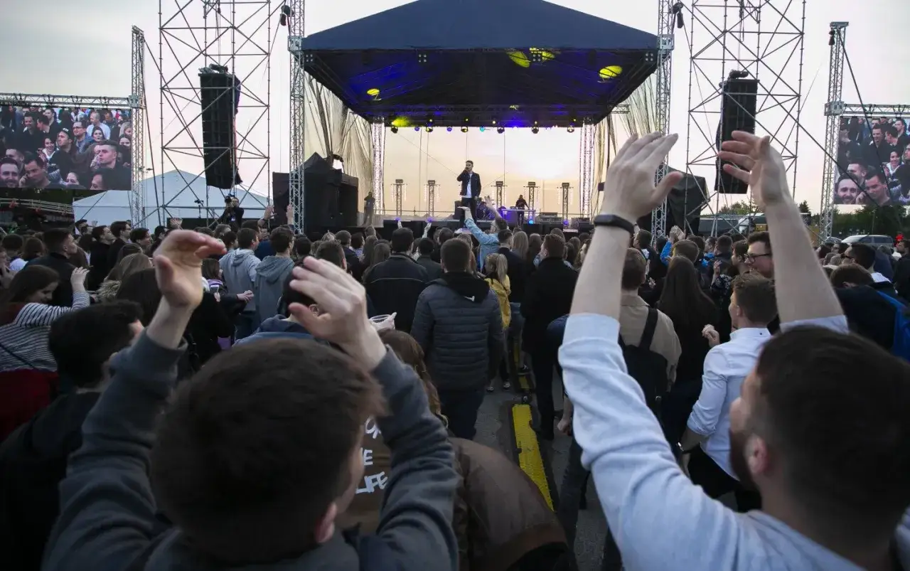 Tłum na juwenaliach WUM bawi się pod sceną, gdzie występuje artysta.