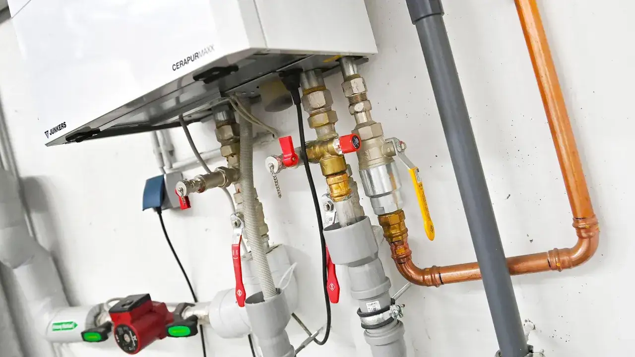 Nahaufnahme einer Junkers CERAPURMAXX Heizung mit Rohren und Ventilen. Informieren Sie sich über die **Biogas Heizung Kosten**.