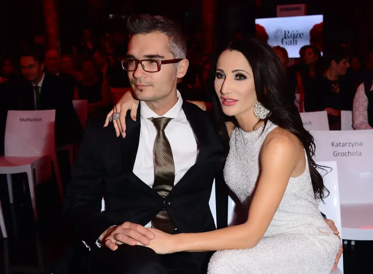 Elegancka para, Maciej Myszkowski i jego partnerka, na gali. Ona w błyszczącej sukni, on w garniturze.