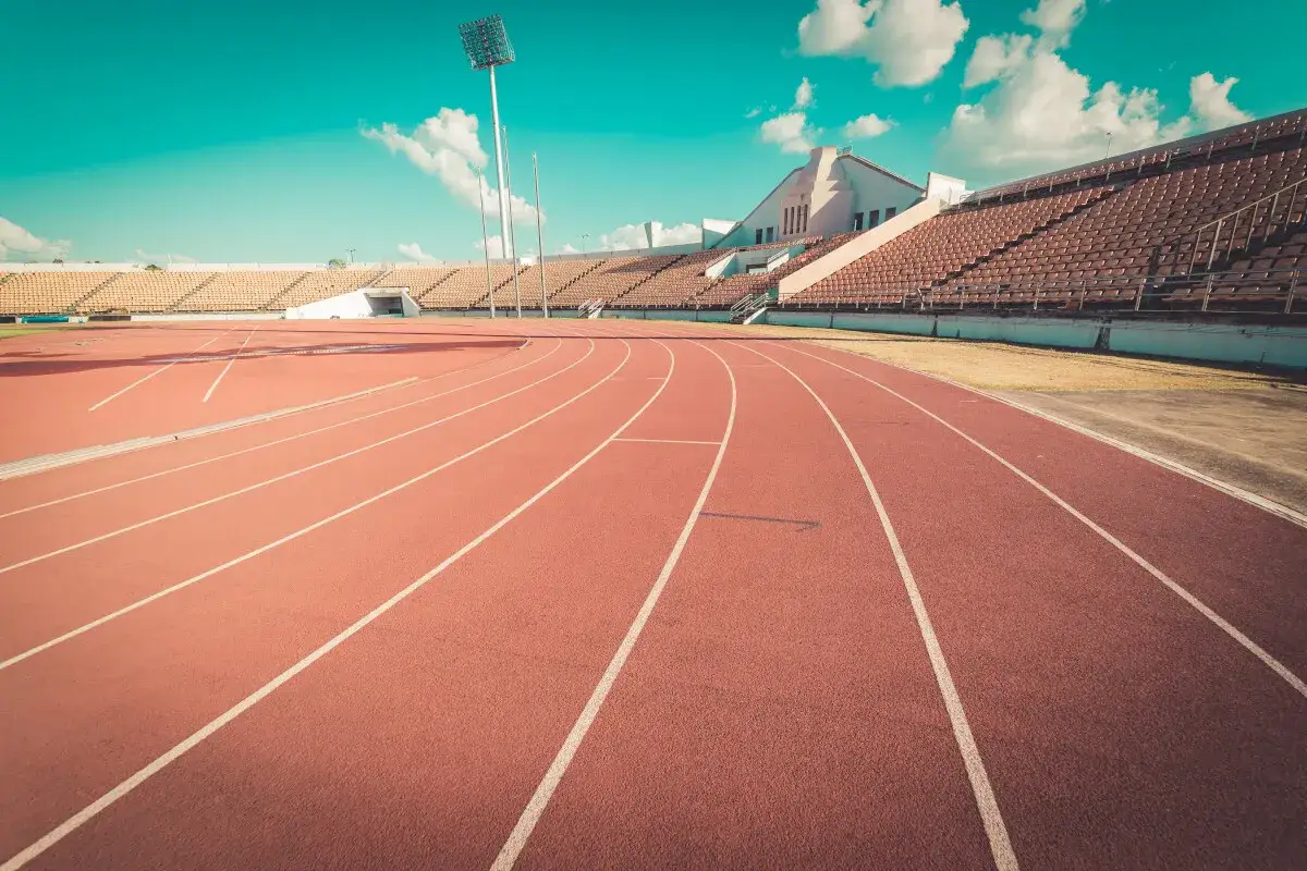 Pusta bieżnia stadionu z widocznymi torami. Standardowa bieżnia ma 400 metrów.