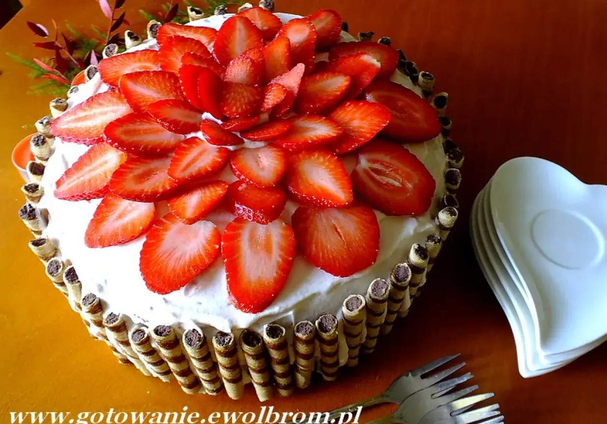 Pyszny tort truskawkowy, udekorowany świeżymi owocami i wafelkami. Idealny na każdą okazję!