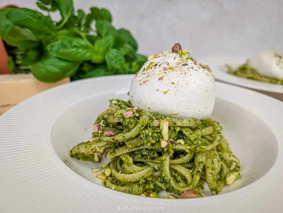 Makaron z pesto, kremową burratą i pistacjami. Pyszne danie, które można przygotować z pesto ze słoika i odrobiną śmietany.